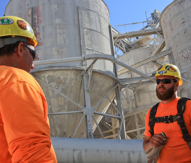 two men in hard hats talking on site